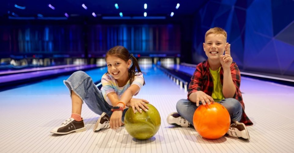 Children sitting on the lane in bowling alley