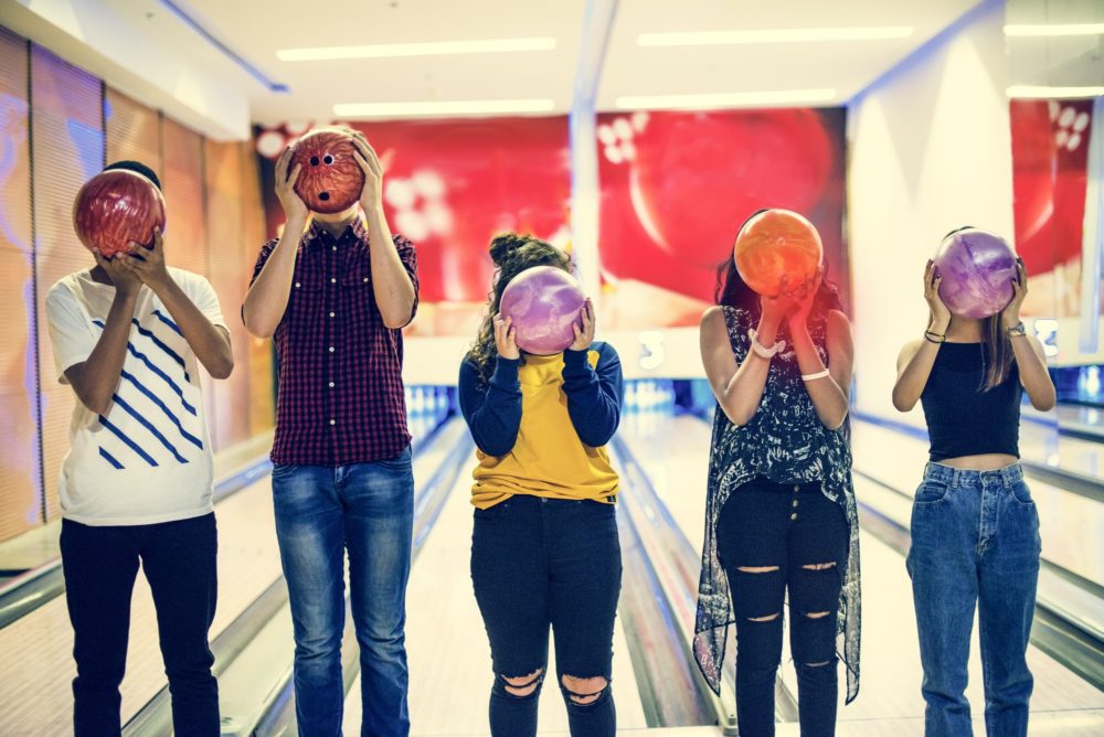 Friends bowling together indoors