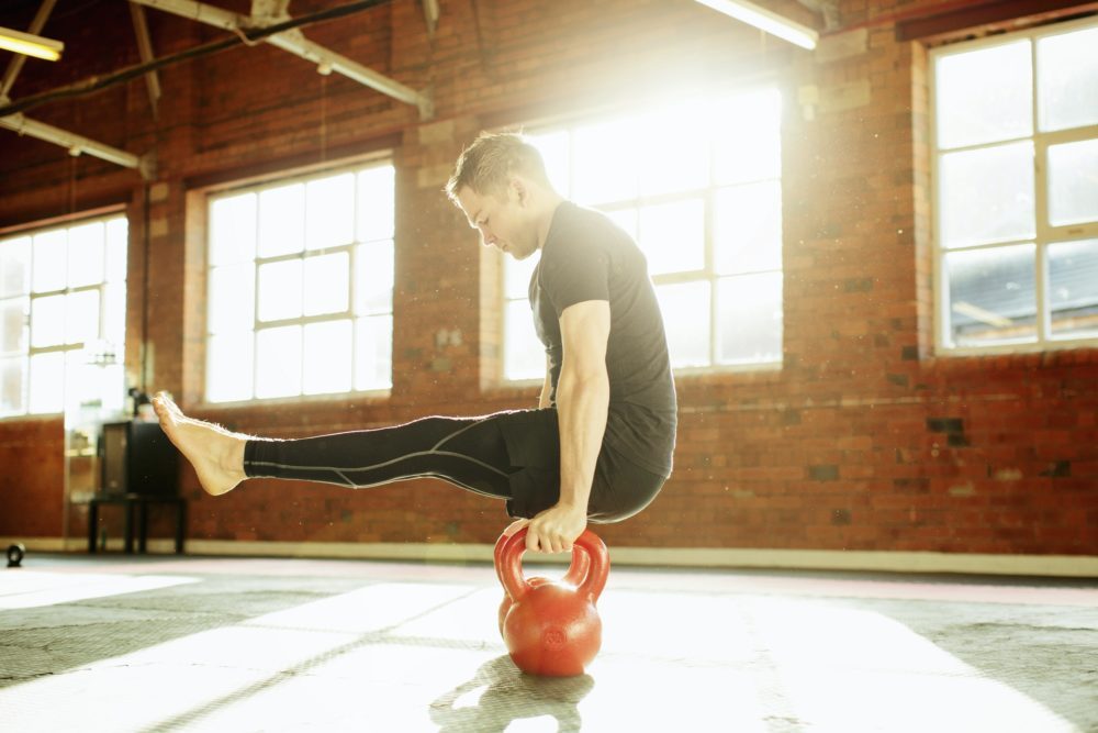 Man strength training with kettle bells