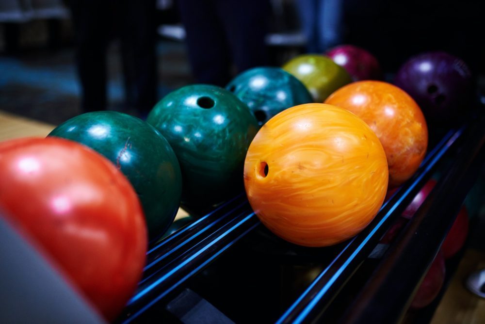Stand with colorful bowling balls in club