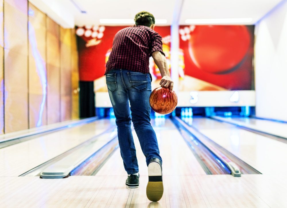 Boy about to roll a bowling ball hobby and leisure concept