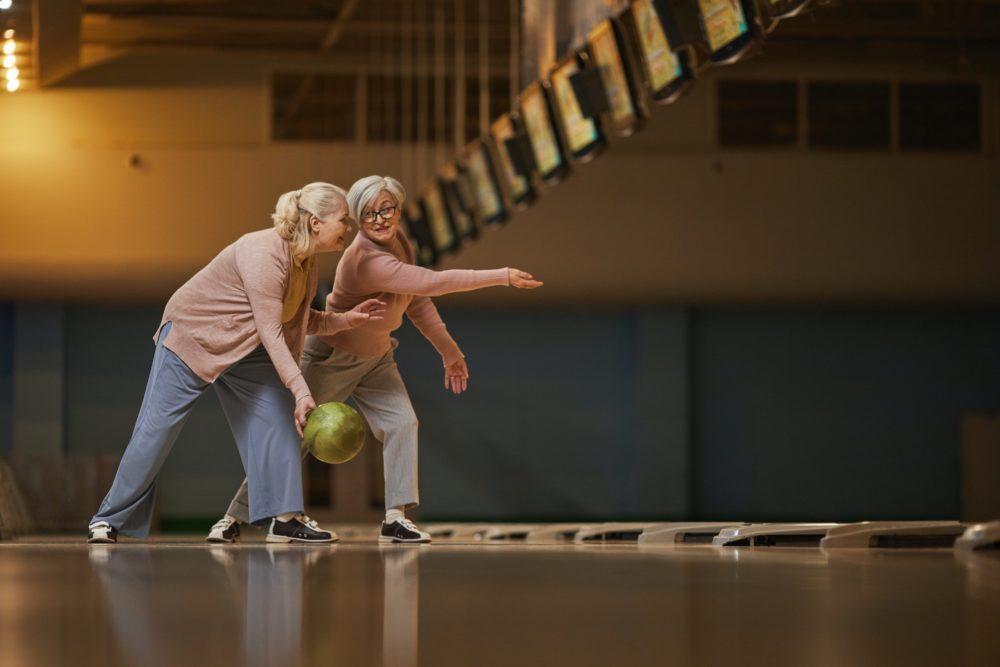 Two Senior Women Playing Bowling Side View