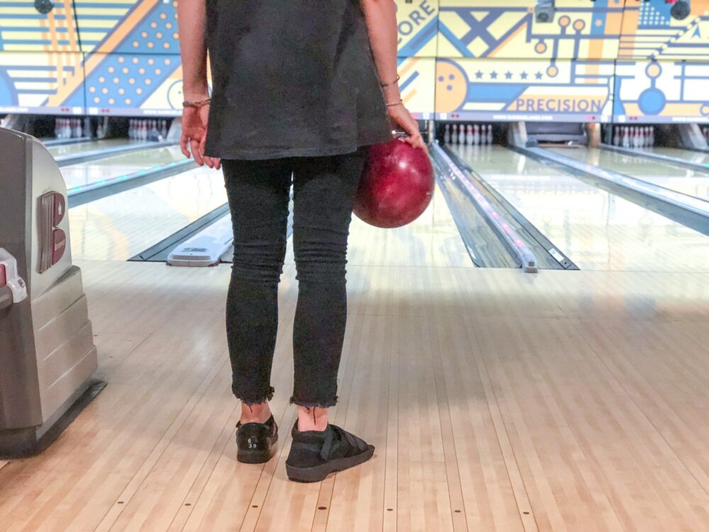 Woman at the bowling alley with bowling ball in hands ready to bowl